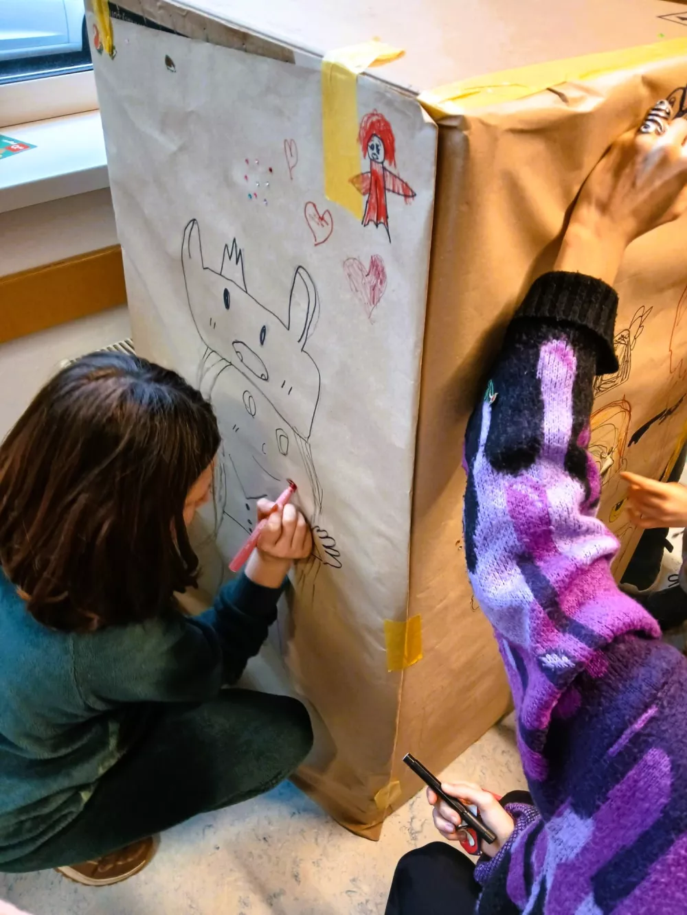kinderen kleuren op groot papier