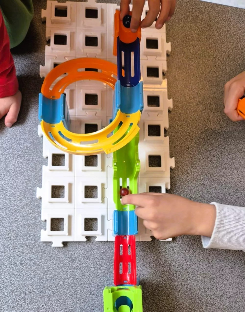 kinderen spelen met knikkerbaan